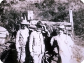 Carlos Chagas, de chapéu e terno claros, à direita, acompanhado de dois homens de chapéu, em frente a uma carroça puxada por cavalos.