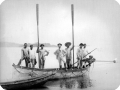 Carlos Chagas (ao centro) e Pacheco Leão (a sua esquerda) no rio Negro, com mais cinco pessoas, em um barco, acabando de deixar o cais. 